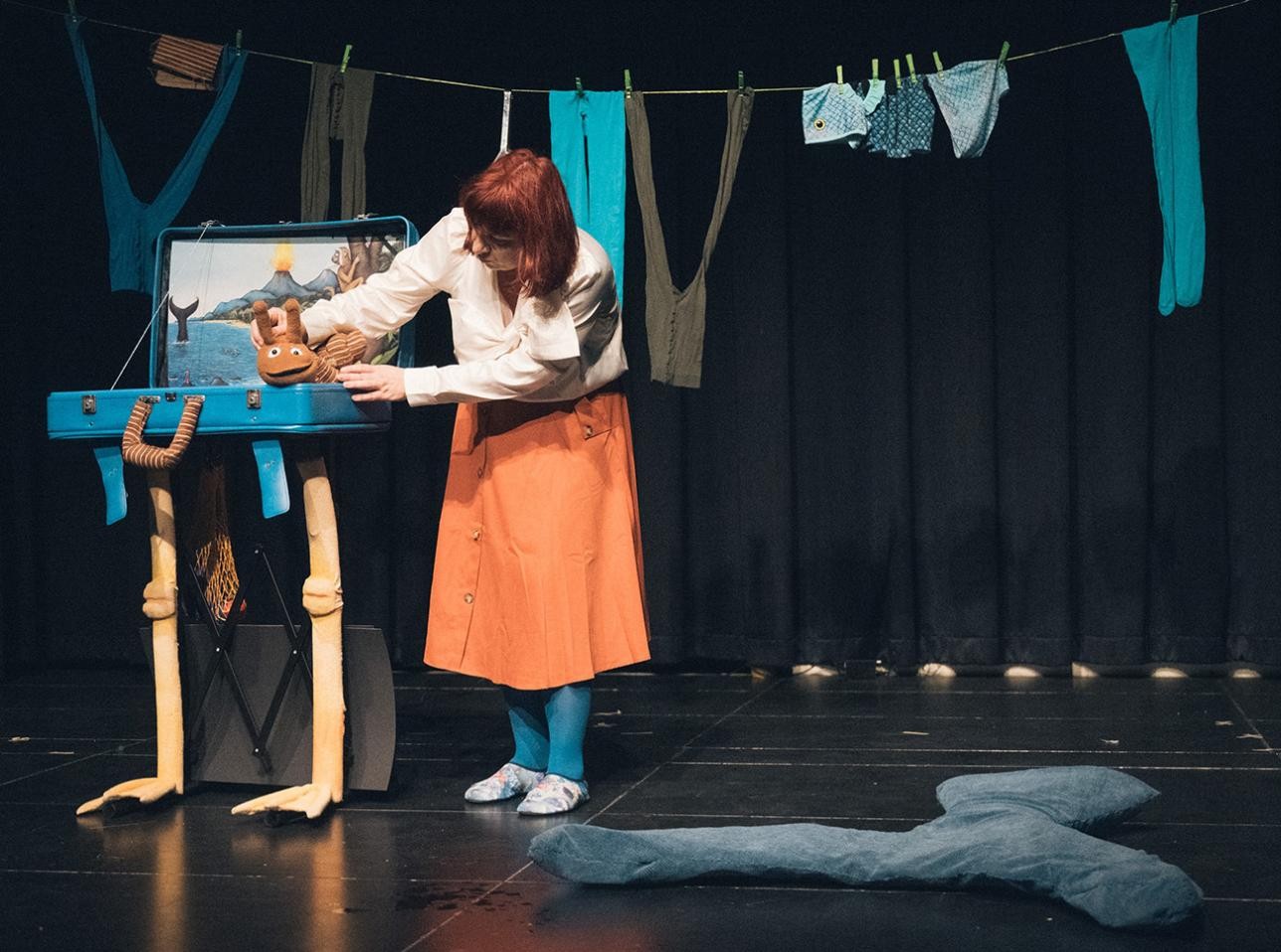 Das LUK-Puppentheater kommt mit dem Stück „Die Schecke und der Buckelwal“ ins Kellertheater. Foto: LUK-Puppentheater Aufführung Luk Puppenthater. Frau hält Handpuppe auf der Bühne in der Hand