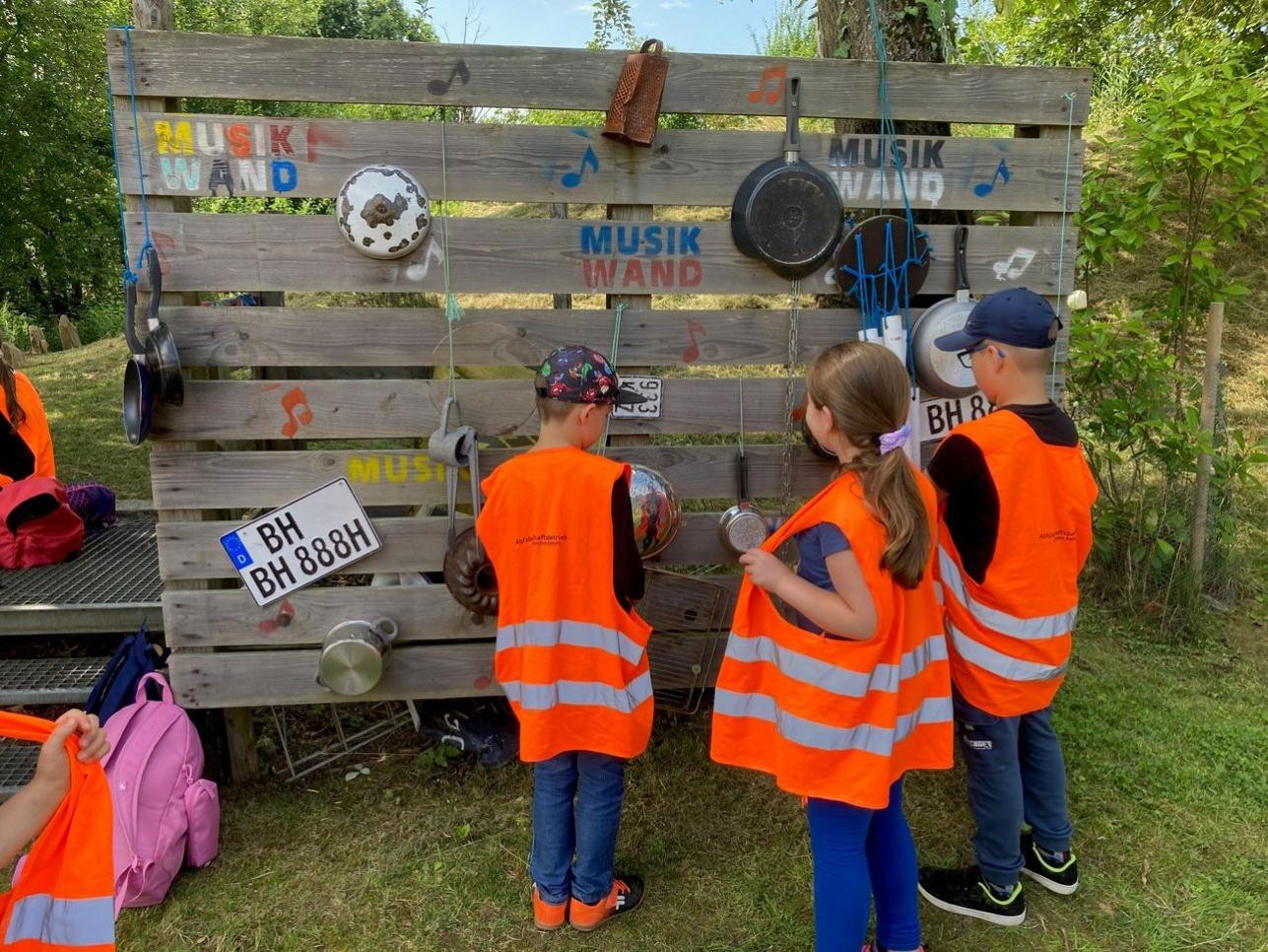 20 Kinder erleben im Rahmen einer Ferienwoche der Gemeinwesenarbeit West und der Fördergemeinschaft der Augusta-Sibylla-Schule fünf erlebnisreiche Tage rund um Natur, Umwelt und Kultur. Foto: Stadt Rastatt/Petra Oser Kinder vor Palettenwand