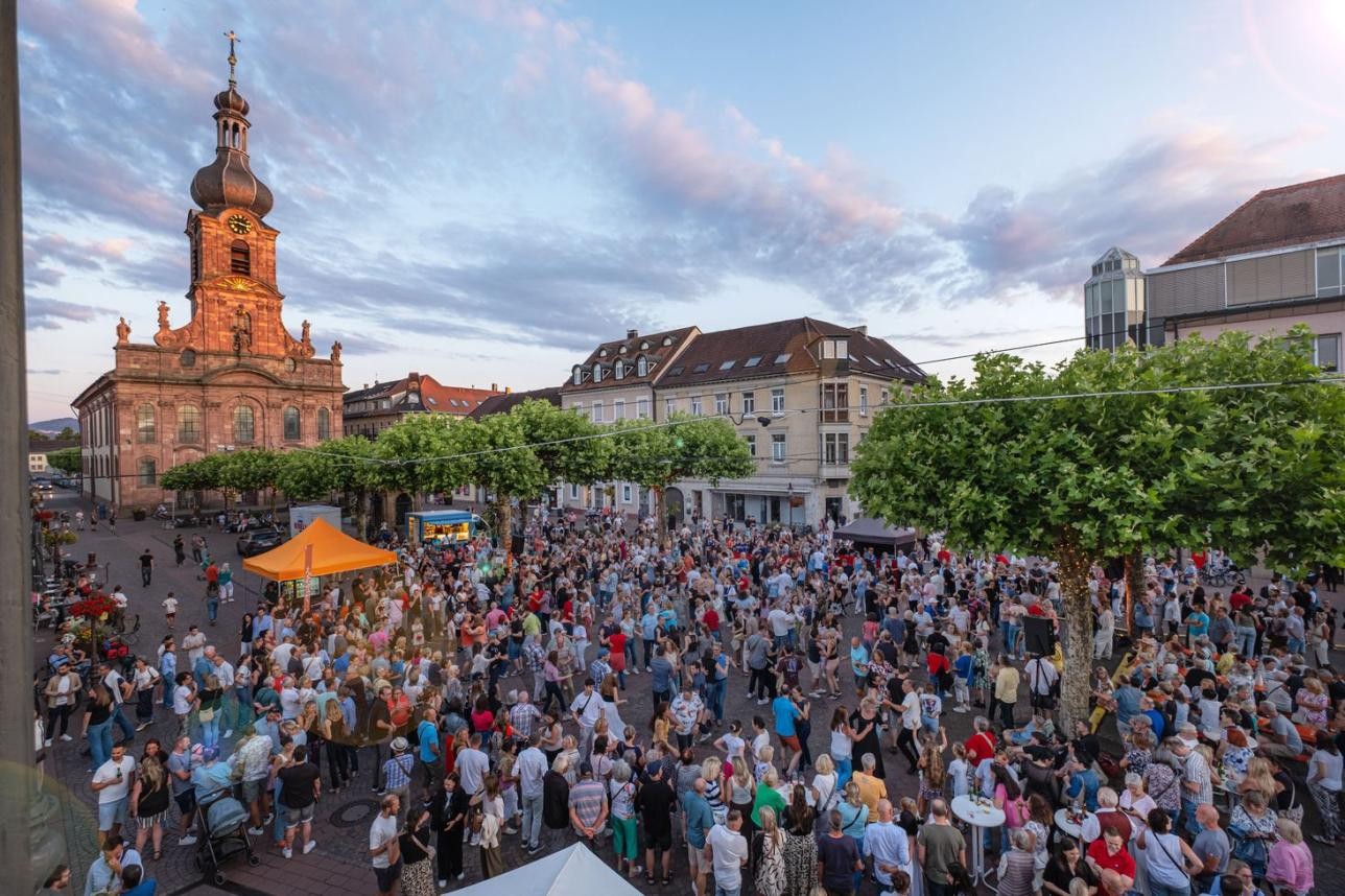 Am Freitag, 14. August, wird unter den Platanen auf dem Rastatter Marktplatz wieder das Tanzbein geschwungen. Foto: Oliver Hurst Menschen tanzen auf dem Marktplatz