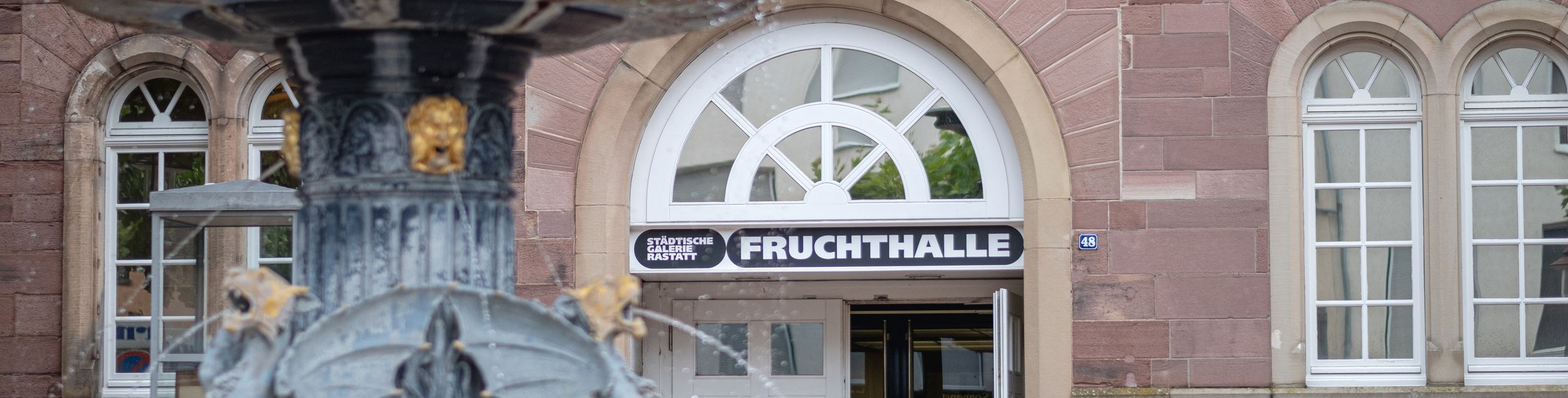 Städtische Galerie Fruchthalle Rastatt, Pfeifferbrunnen mit Eingang Fruchthalle, Foto Oliver Hurst 2021.